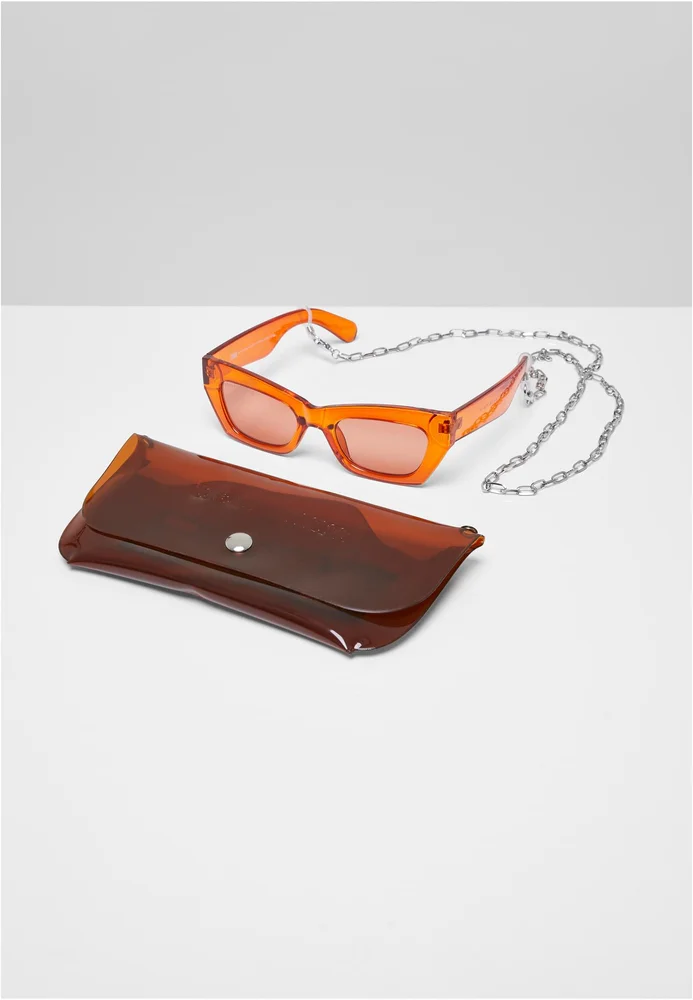Urban Classics Sonnenbrille mit transparentem Kunststoffgestell in Cateye-Form und UV-400-Schutz, inklusive braun/silberner Brillenetui mit Kordelzug, Druckknopf und abnehmbarer Ankerkette. Das Etui besteht aus Polyester, das Accessoire-Set ist im femininen Stil gehalten.